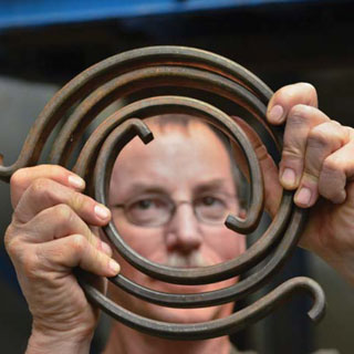 Elton Wright (6916) shows a torsional spring that’s used to simulate the rotational vibration of the drill string in a Sandia experiment. (Photo by Randy Montoya)