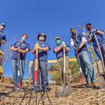 people standing with gardening tools