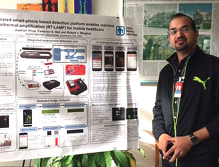 WINNING POSTER — Aashish Priye shows his winning poster in the annual Postdoctoral Technical Showcase at Sandia California. The showcase is held each December at Sandia’s campuses in New Mexico and California to display the breadth of research by postdoctoral employees. (Photo by Jasmine King-Bush)