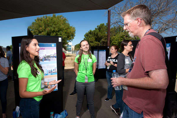 interns discuss their project with visitor