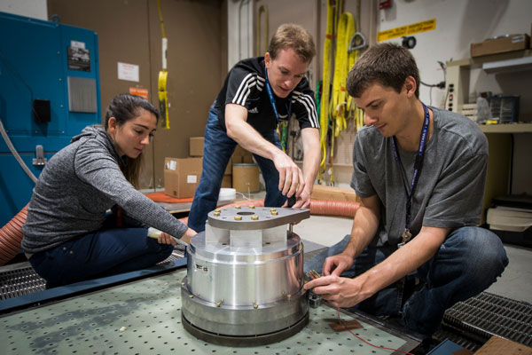 scientists work on vibration test equipment