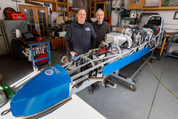 Joel and Jack Wirth work on roadster in garage