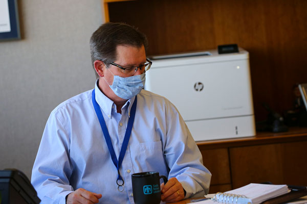 Labs Director working at desk wearing face masks