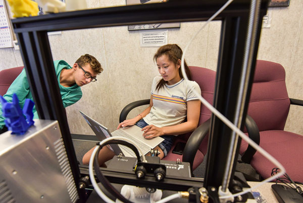 Students collaborate over laptop