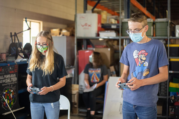 two kids compete to navigate their team's robots through a course