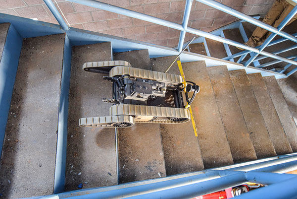 A robot maneuvers down stairs