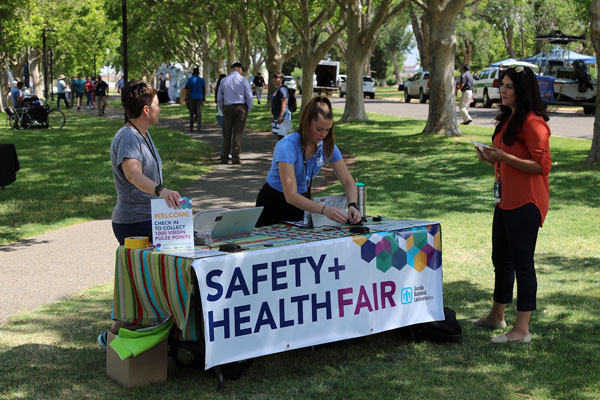 people at welcome booth at outdoor safety fair