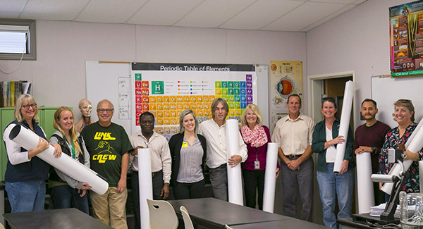 Livermore High School science teachers pose with Sandia Community Relations Officer Madeline Burchard (center), holding their new classroom tables.