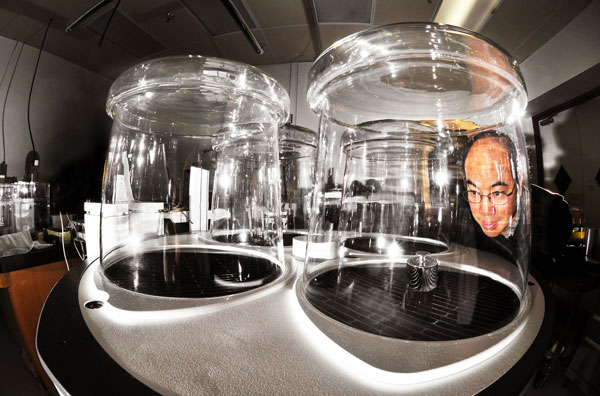 Hy Tran examines a kilogram sample in a mass comparator at Sandia National Laboratories’ Primary Standards Laboratory in 2008. Tran led the team of scientists looking to redefine the kilogram by basing it on standards of universal constants rather than on an artifact standard. (Photo by Randy Montoya)