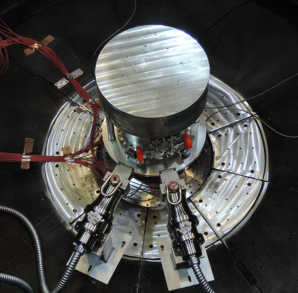 Two fast neutron radiation-effects cassettes aim toward the center of the containment system for tritium within the Z vacuum chamber. The setup’s gas transfer system is housed within the containment system.
