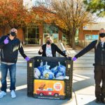 volunteers stand next to turkey collection bin