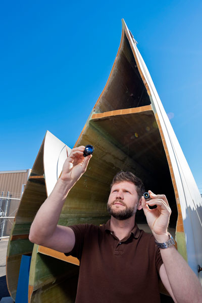 engineer inspects small camera in front of wind turbine