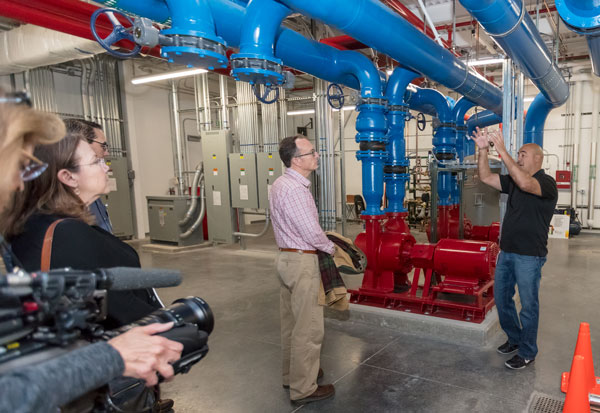 SAVING THIS MUCH WATER — David J. Martinez (right) describes to Warren Hunt and others the water conservation successes in the supercomputer cooling effort that David leads. (Photo by Rebecca Gustaf)
