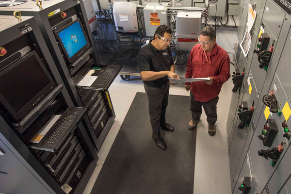 THE FUTURE OF ENERGY — Sandia manager Abraham Ellis and technologist Roy Lopez discuss future energy technologies research in Sandia’s Distributed Energy Technologies Laboratory. Sandia and Emera Technologies, an Emera company, signed a Cooperative Research and Development Agreement that enables them to share tools and research focused on future energy microgrids. (Photo by Randy Montoya)