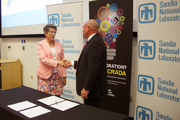 RESEARCH PARTNERS — Sandia associate labs director Dori Ellis shakes hands with Emera Technologies CEO Rob Bennett following the signing of a Cooperative Research and Development Agreement between the Laboratories and the utility company. (Photo by Lonnie Anderson)