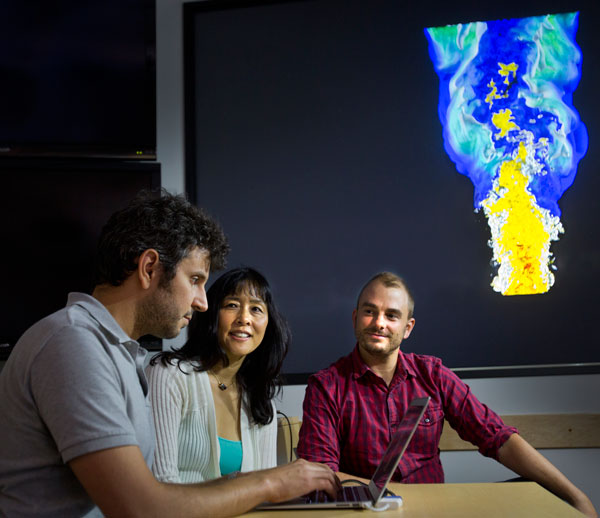COOL FLAMES — Sandia researchers Giulio Borghesi, left, Jackie Chen, center, and Alex Krisman discuss a flame simulation. (Photo by Dino Vournas)