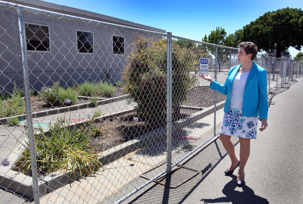 CHANGES ON CAMPUS — Dori Ellis walking past the California site's Redwood Center, which is currently being demolished. (Photo by Dino Vournas)