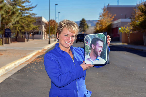 ACE — Consequence assessor Theresa Rolfe holds a photo of her son Ted Benoit. Rolfe started the Family and Friends of Addicts Support Group at Sandia to give employees a place to share what they’re going through. Her son was addicted to heroin and now works full-time at a recovery center in Connecticut where he helps men with drug and alcohol addiction.