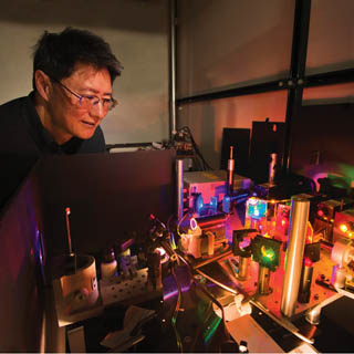 A LIGHT TOUCH — Jeff Tsao examines initial setup used to test diode lasers as an alternative to LED lighting. Skeptics felt laser light would be too harsh to be acceptable. Research by Jeff and his colleagues suggests the skeptics are wrong. (Photo by Randy Montoya)