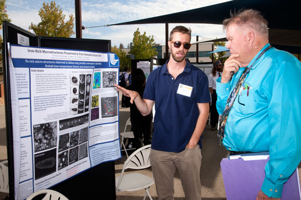Timothy Genda (left) a graduate student from UC Berkeley, shows off his work to John Taylor, an NSSC Advisory Board member and retired Sandia staff member.