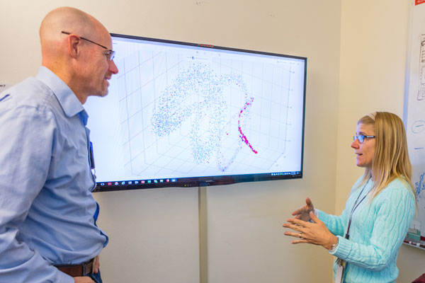 COACHING SESSION — Computer scientist Kurt Larson (left), a “coach” in Division 6000’s Research Club, discusses data in a visualization algorithm with fellow computer scientist Jenny Galasso, part of her Exploratory Express research proposal. (Photo by Nicholas Kerekes)