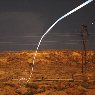 A tiny light-emitting diode, or LED, attached to a bullet shows a bright path during a nighttime field test that proved the battery and electronics could survive the bullet’s launch. (Photo by Scott Rose)