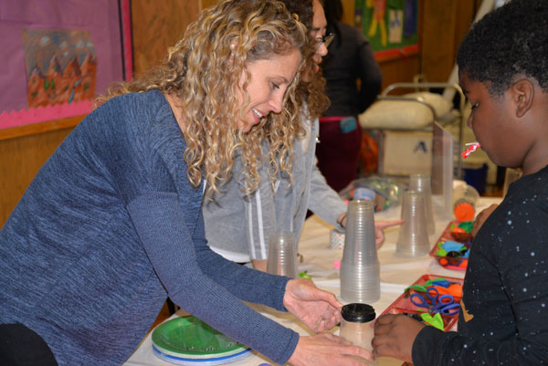 AIMING HIGHER — Software engineer Marisa Stansfield helps a student build a balloon-launching ‘airzooka.’