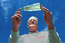 MESSAGE IN A BOTTLE -- Retired Sandian Harold Myers shows off a sample of the kind of bottle he uses in his unusual hobby: casting messages in bottles into the open sea from the weather decks of cruise ships. Harold has received five replies to the 15 messages he has sent so far. (Photo by Randy Montoya)Download 150dpi JPEG image, 'bottle_pix.jpg', 1 Mb