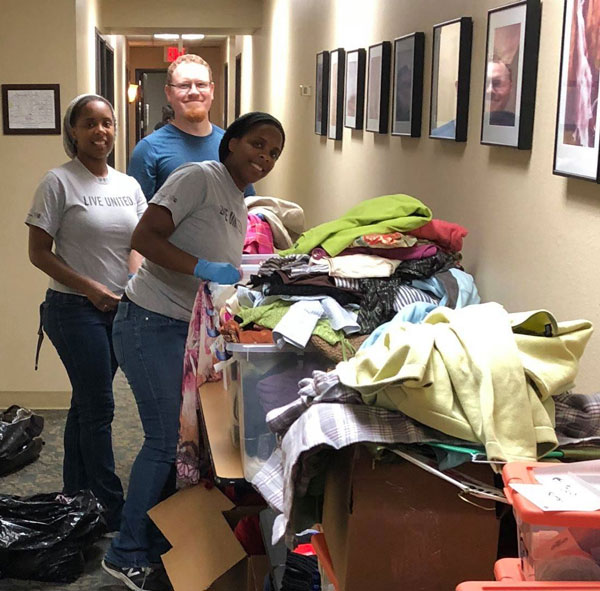 GETTING ORGANIZED — Sandia computer scientist Matthew Hoffman from Guys Give and Sandia engineers Imani (left) and Shauna Adams of the Young Leaders Society organize the clothing closet at the Family Advocacy Center where domestic violence victims can find items such as diapers, socks, underwear and other clothing after escaping an abusive situation. (Photo by Paul Vuchetich, United Way)