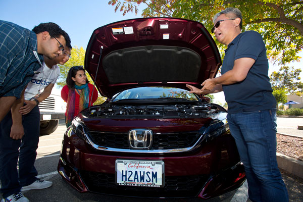 DRINK HIS EXHAUST — Lawrence Livermore materials scientist Tadashi Ogitsu (right) brought his hydrogen fuel-cell powered Honda Clarity for celebration attendees to check out. Ogitsu likes to remind people the only exhaust from his vehicle is water. (Photos by Jules Bernstein)