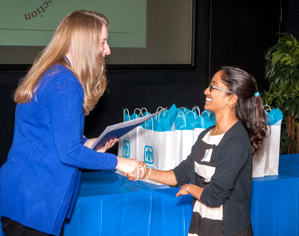 Heidi Ammerlahn, left, with the Sandia National Laboratories Women’s Connection and the director of homeland security and defense systems, congratulates a student at the 2018 Sandia Math and Science Awards.
