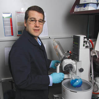 IRON?MAN - Dale Huber, working with retired Los Alamos National Laboratory researcher Ed Flynn and his company, Senior Scientific LLC, is using the tools of nanotechnology to grow nanoscopic iron oxide particles as part of an approach to provide early detection of cancer cells. The blue material here is a solution of cobalt chloride, a salt that can be used as a precursor to magnetic nanoparticles. (Photo by Lloyd Wilson)