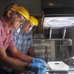 Joshua Stein, a Sandia systems engineer and director of the new Perovskite Photovoltaic Accelerator for Commercializing Technologies Center, left, prepares a solar module for testing at the Labs’ Photovoltaic Systems Evaluation Laboratory, which will be used to support the commercialization of U.S. perovskite-based photovoltaic technologies.