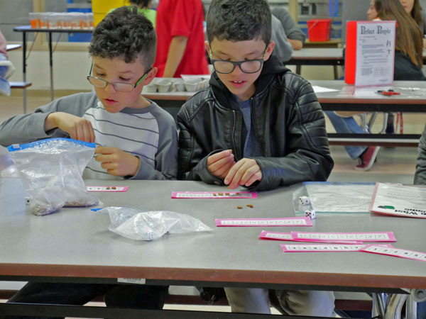 TWINS — Oliver and Jasper Wissing challenge each other with a dice game during Family Math Night at Tomasita Elementary School, March 14. The boys, in third grade, said they “love numbers.”