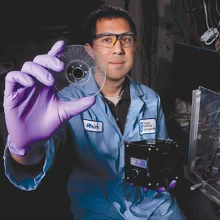 DISK JOCKEY — Ulrich Schaff holds a prototype SpinDx, a portable instrument for running assays for toxins and other substances. The SpinDx botulinum assay outperformed the current “gold standard” botulinum test, mouse bioassays, and has the potential to become a powerful biodefense diagnostic tool. (Photo by Randy Wong)