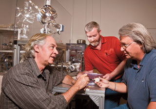 HELLO, MR. CHIPS — Juan Elizondo-Decanini (2735), left, Matt Senkow (2735), right, and Kevin Youngman (2625) discuss a new configuration for neutron generators. A three-year Laboratory Directed Research & Development project Juan led demonstrated the basic technology necessary for a tiny, mass-produced, chip-based neutron generator that he said can be adapted to medical and industrial applications. (Photo by Randy Montoya)