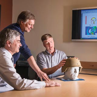 BRAIN POWER — Paul Taylor (5431), right, talks with John Ludwigsen (also 5431), center, and Corey Ford, a neurologist at the University of New Mexico’s Health Sciences Center, about their research on traumatic brain injuries. The three researchers are comparing supercomputer simulations of the physical effects of blast waves on the brain with Ford’s analyses of patients who have suffered such injuries. (Photo by Randy Montoya)