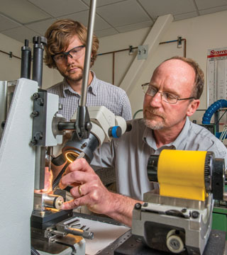 INSPECTION — Ray Ely, left, and Dennis Kuchar (both 2613) inspect launch accelerator hardware before assembling units for critical flight tests. Their work is part of Sandia’s long-time effort on stronglinks.	(Photo by Randy Montoya)