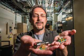 Image of <p>Ron Manginell and colleagues are developing new miniature pulsed-discharge ionization detectors — mini-PDIDs — like those Ron is holding here. The tiny devices have broadened the scope of chemical targets for Sandia’s microanalytical detection technology to toxic industrial chemicals, biological volatiles, greenhouse gases, and more. (Photo by Randy Montoya)</p>