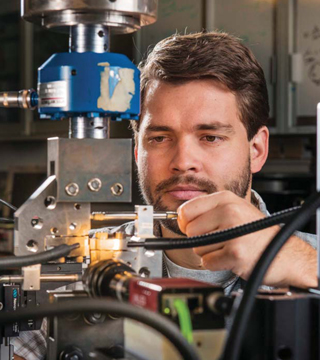 LASER WELDS — Researcher Brad Salzbrenner (1831) tests laser-welded objects in pure tension, shear, and mixed tension-shear loading. One pilot study in Sandia's long-term Predicting Performance Margins program involves laser welds, which are widely used in engineered systems. (Photo by Randy Montoya)