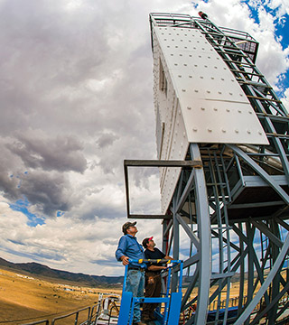 Technologists John Kelton and Daniel Ray inspect the Falling Particle Receiver during a cloud delay atop the National Solar Thermal Test Facility at Sandia National Laboratories.	(Photo by Randy Montoya)