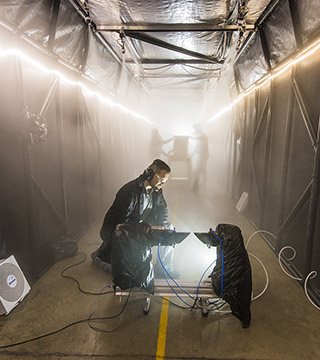 Andres Sanchez (6633) checks an instrument that measures the particle size and concentration in the atmosphere inside one of the world’s largest fog chambers developed by Sandia. (Photo by Randy Montoya)