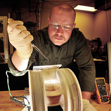 KYLE SOLIS (in photo at left), a graduate student intern in Nanomaterials Sciences Dept. 1112, prepares a sample for mixing using a new approach called vortex field mixing, developed by researchers in his organization. (Photo by Randy Montoya)
