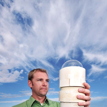 EYE ON THE SKY Ñ Dale Jackson (5737) checks out a Sentinel network all-sky video camera system prior to installation at SandiaÕs LAZAP facility. A Sentinel system consists of a small, inexpensive black-and-white video camera equipped with a fisheye lens, with digitized video fed to a PC. Almost 100 Sentinel systems are deployed and monitored by volunteers in 11 states and five Canadian provinces. SandiaÕs Sentinel camera and a unit in Lamy, N.M., recorded a significant meteor event in the early hours of Oct. 9. (Photo by Randy Montoya)