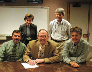 On Sept. 24 Sandia President and Labs Director Tom Hunter signed the W76-1 Final Weapon Development Report providing Sandias certification of the W76-1 warhead. Pictured with Tom (seated in the center) at the signing ceremony are, from left, Steven Barnhart (2132), Kathleen Diegert (0413), Robert Paulsen (2011), and Mark Rosenthal (2130).