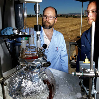 STRANGE BREW Ñ LeRoy Whinnery, left, and Greg OÕBryan mix up a batch of chemicals used to make crystal methamphetamine during field tests to determine the ability of various sensors Ñ including airborne sensors Ñ to detect an effluent signature or mix of chemicals that might suggest illegal drug manufacturing. The project was funded by US Northern Command (USNORTHCOMM).	(Photo by Randy Wong)