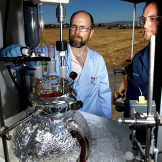 STRANGE BREW Ñ LeRoy Whinnery, left, and Greg OÕBryan mix up a batch of chemicals used to make crystal methamphetamine during field tests to determine the ability of various sensors Ñ including airborne sensors Ñ to detect an effluent signature or mix of chemicals that might suggest illegal drug manufacturing. The project was funded by US Northern Command (USNORTHCOMM). (Photo by Randy Wong)