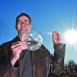 BRILLIANT! — Greg Nielson, just named to Popular Science’s annual Brilliant 10 list, holds a solar cell test prototype with a microscale lens array fastened above it. Together, the cell and lens help create a concentrated photovoltaic unit. (Photo by Randy Montoya)