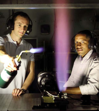 Image of <p>PLAYING WITH FIRE — Adam Ruggles (8351) and Isaac Ekoto (8367) pinpoint the ignition boundary from an unintended release of high-pressure hydrogen gas. Their research provides a scientific basis for establishing separation distances for hydrogen infrastructure. (Photo by Dino Vournas)</p>