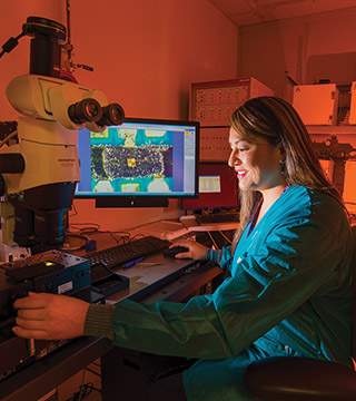DEVICE AGING STUDIES — Rachelle Thompson (1356) inspects an electronic device that is part of a 30-year Sandia program that looks at how environments, including radiation from a nuclear weapon itself, could affect the performance of electronics inside a W76-1 warhead. The study begun in 2006 will provide real-time data for the first time on how electronics age within the weapon. (Photo by Randy Montoya)